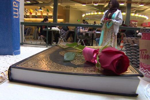 تصویر توزیع گل های رز مزین به آیات قرآن و حدیث، در مراسم هفته شناخت اسلام در دانشگاه کانادا