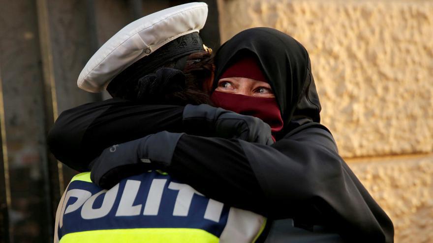 تصویر تحقیق پلیس دانمارک درباره افسری که زن معترض برقع پوش را در آغوش گرفت